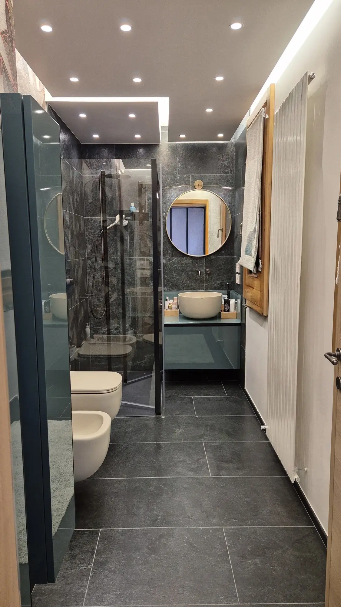 Mobile laccato verde petrolio con doppio lavabo d&rsquo;appoggio e carta da parati botanica