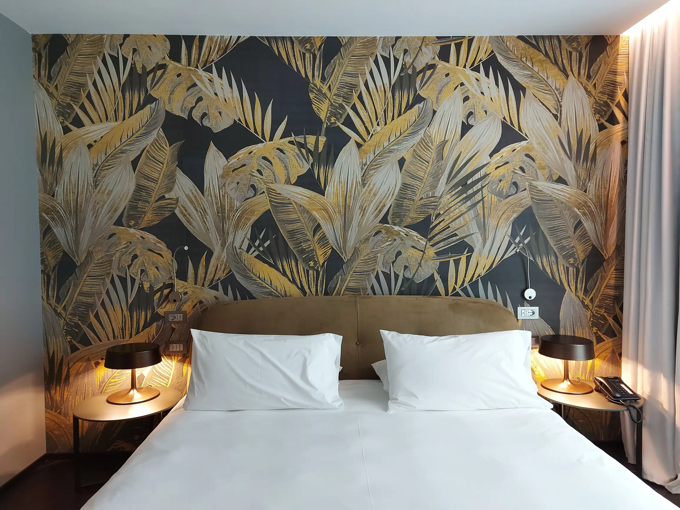 Camera da letto con carta da parati decorativa e testata imbottita